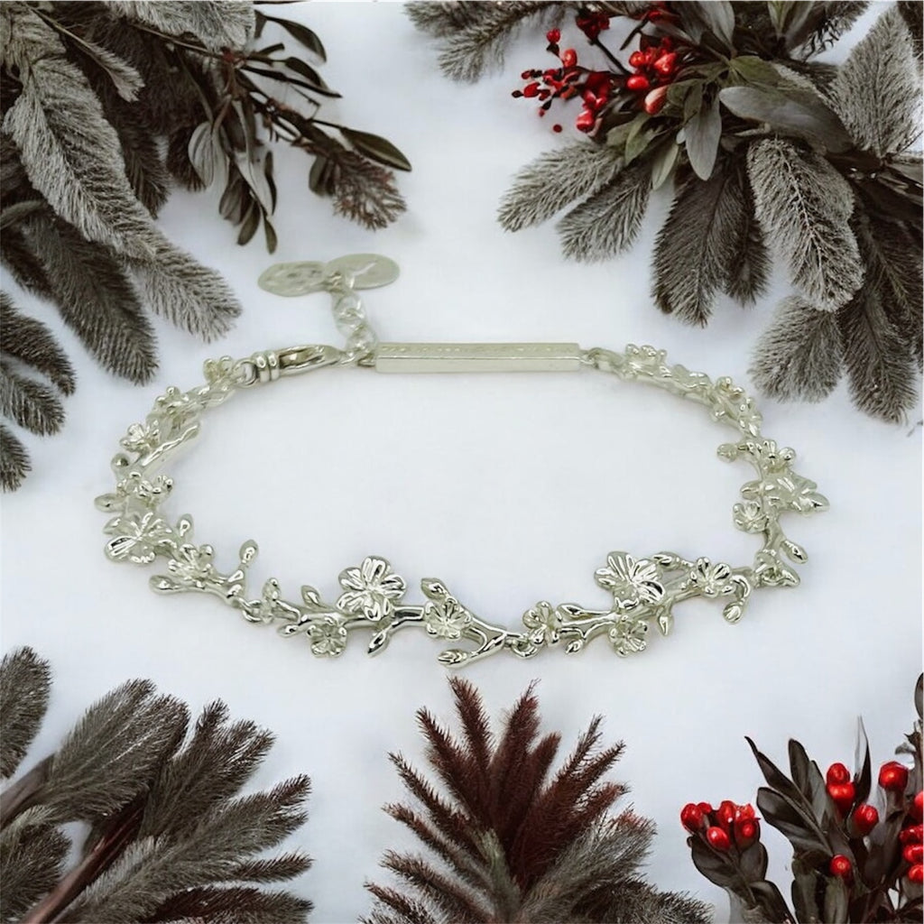 Silver bracelet on a white background with decorative plants and berries