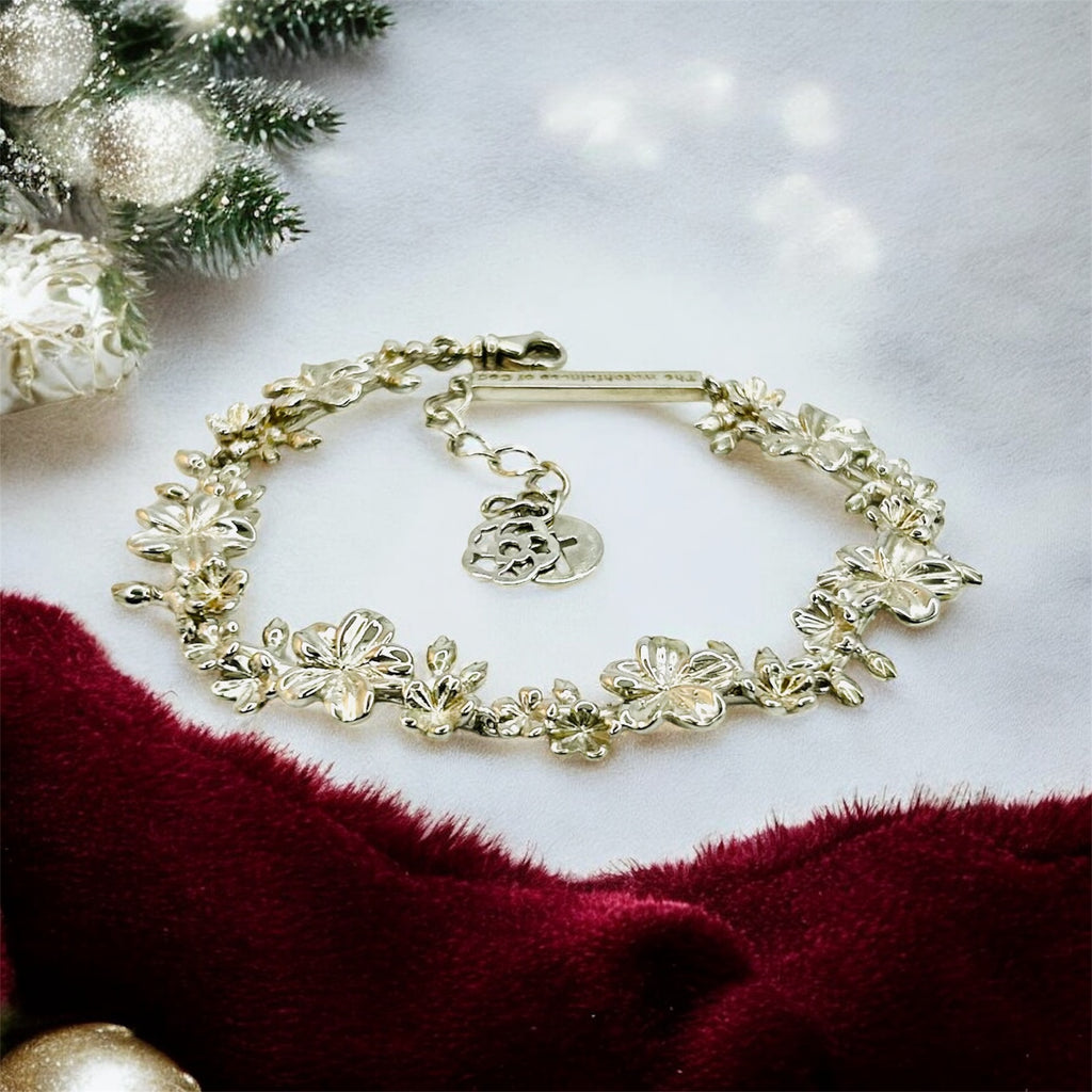 Gold bracelet on a white surface with festive decorations