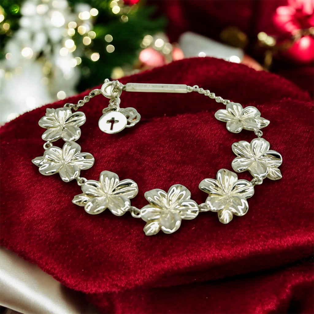 Silver floral bracelet on a red surface with a blurred festive background