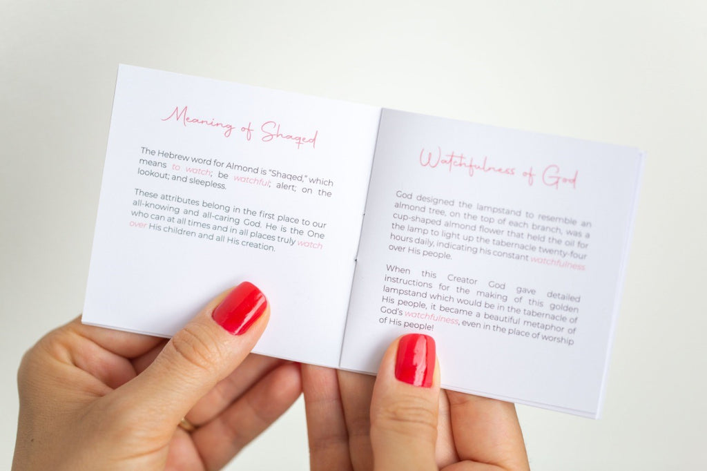 a woman holding a booklet describing the Bibical meaning of the almond blossom in our jewelry