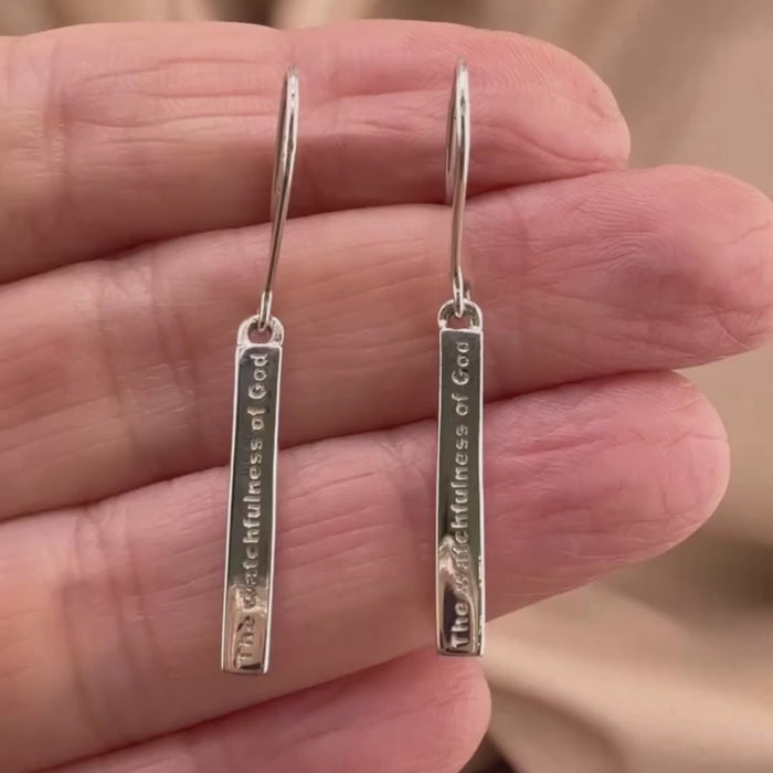video showing the details of our Watchfulness of God bar earrings on a womans hand.