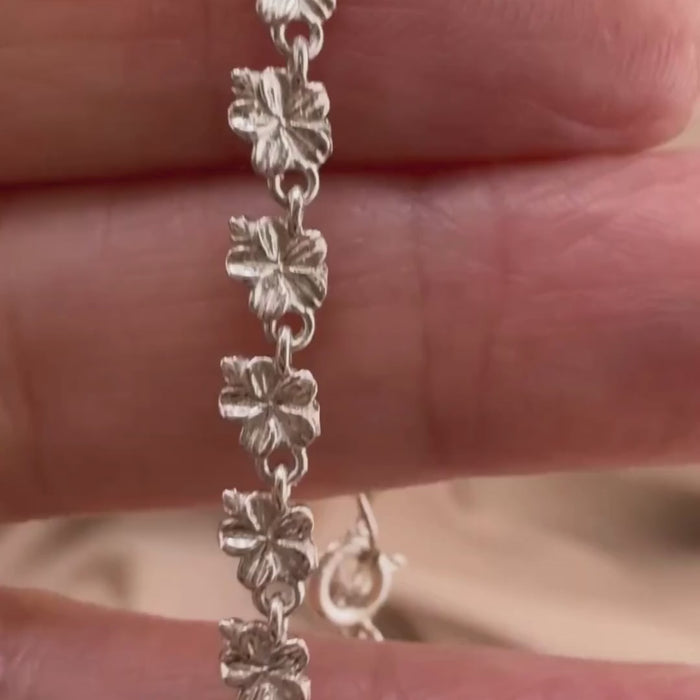 Sterling silver Christian bracelet  of a floral almond blossoms design on  woman's hand showcasing details 