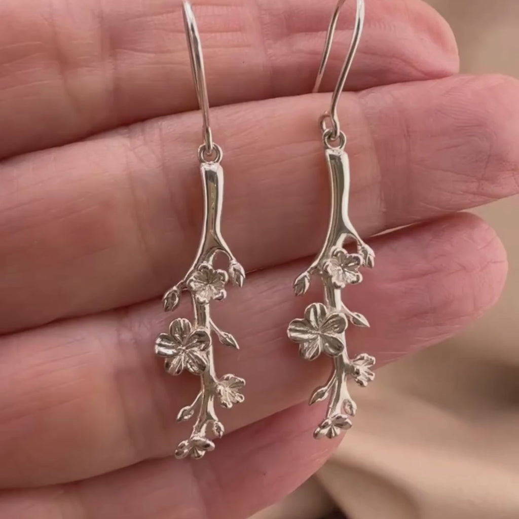 Video of Christian Earrings in sterling silver, elegantly designed with delicate almond blossom details, symbolizing God's watchfulness and divine purpose (Esther 4:14). Earrings, the branch of an almond tree in sterling silver hook style on the hand of a woman 