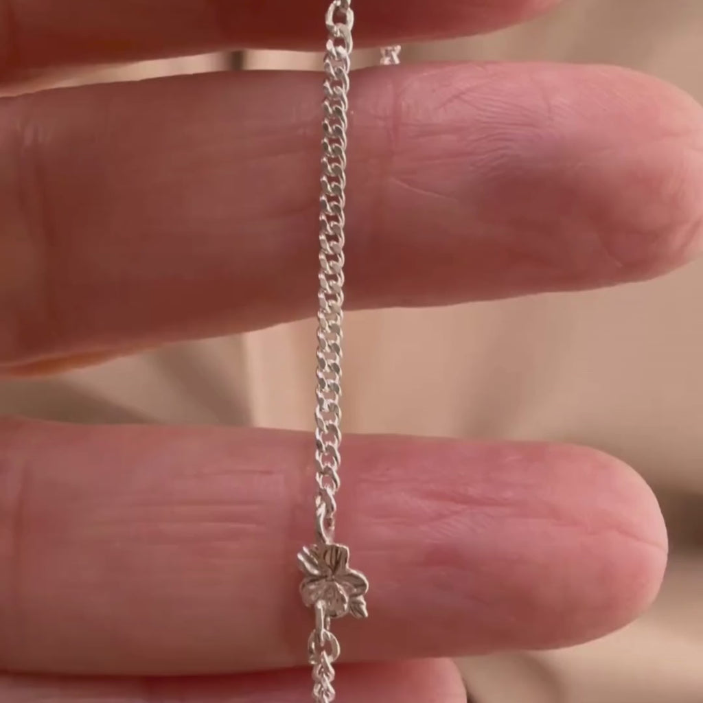 Sterling silver Christian bracelet  of a floral almond blossoms design on  woman's hand showcasing details 