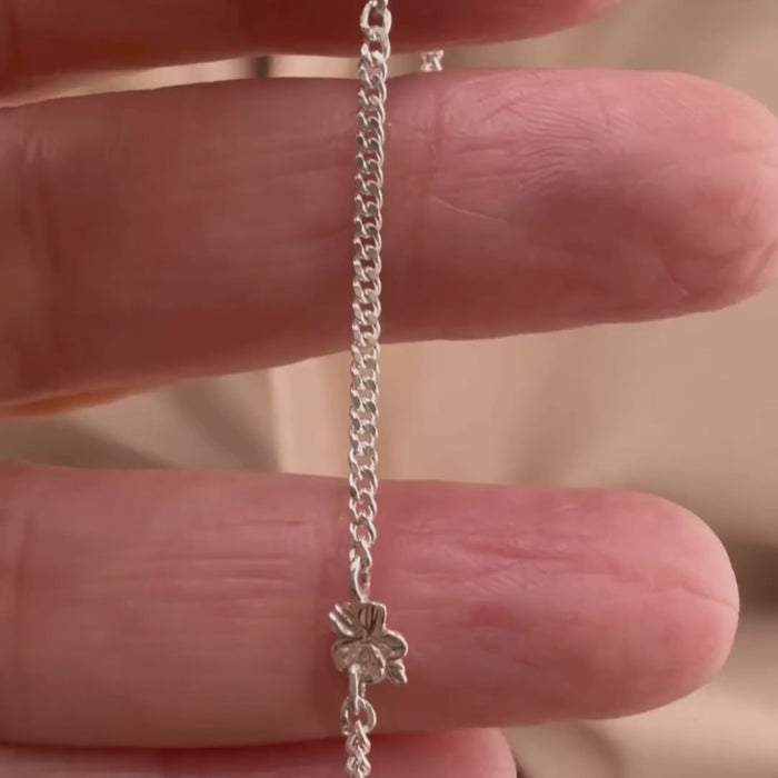 Sterling silver Christian bracelet  of a floral almond blossoms design on  woman's hand showcasing details 