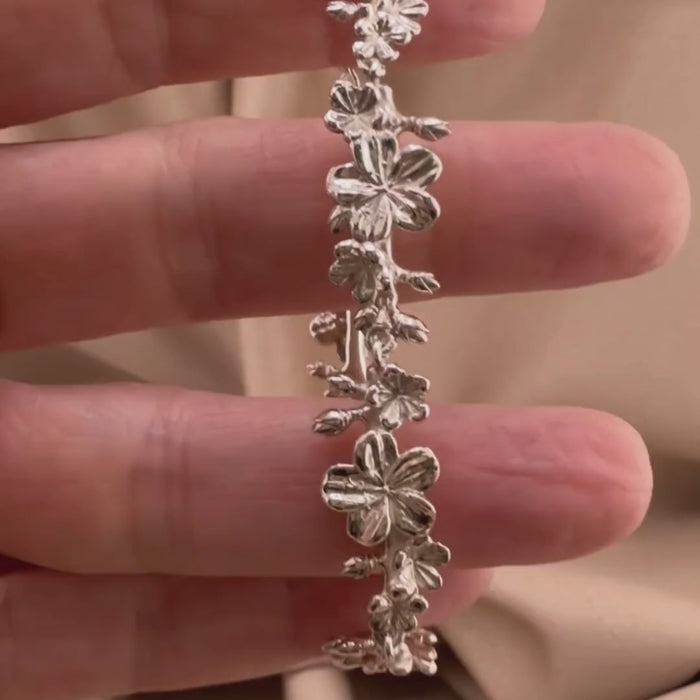 Sterling silver Christian bracelet  of a floral almond blossoms design on  woman's hand showcasing details 