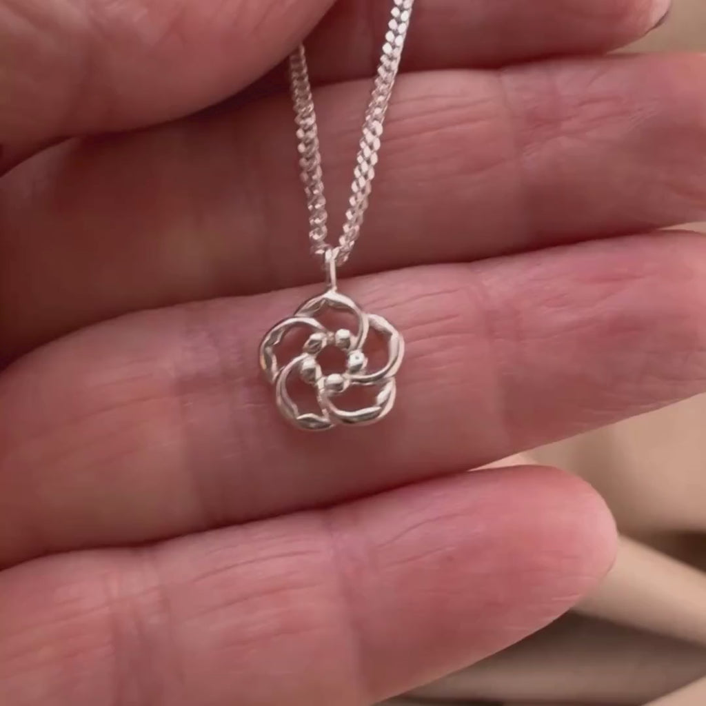 Video of our Amond blossoms Necklace - Chosen and Seen in Sterling silver showing the details of this Christian necklace displayed on the hand of a woman.